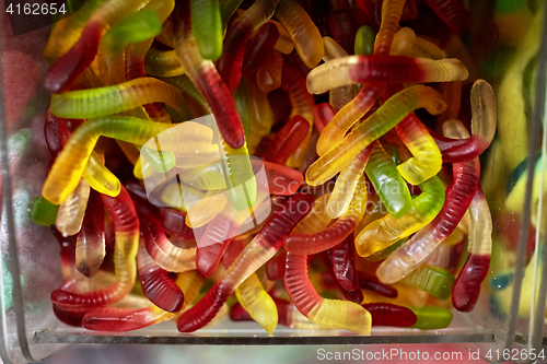 Image of close up of gummy worms in box at candy shop