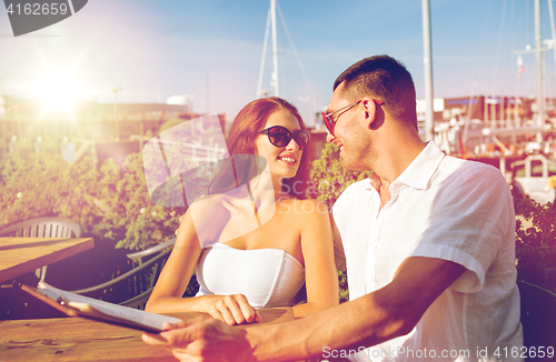 Image of smiling couple with menu at cafe