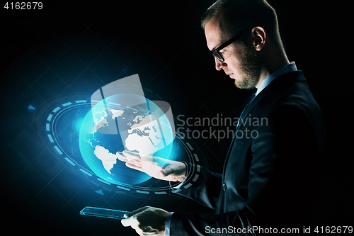 Image of businessman with tablet pc and earth hologram