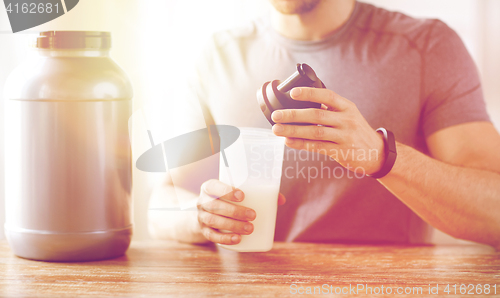 Image of close up of man with protein shake bottle and jar