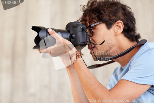 Image of close up of  photographer with camera shooting