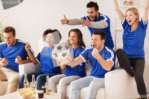 Image of friends or football fans watching soccer at home