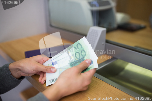 Image of hands with money at bank or currency exchanger