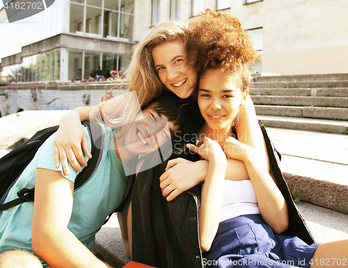 Image of cute group of teenages at the building of university with books 