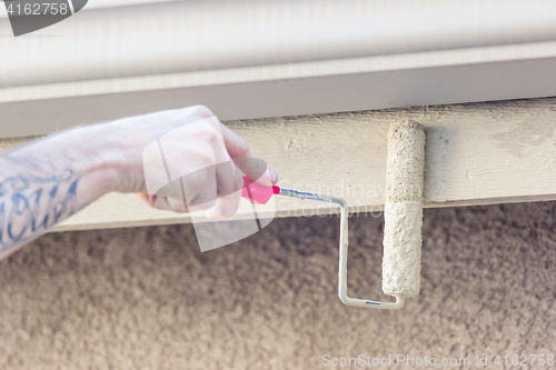 Image of Professional Painter Using Small Roller to Paint House Fascia