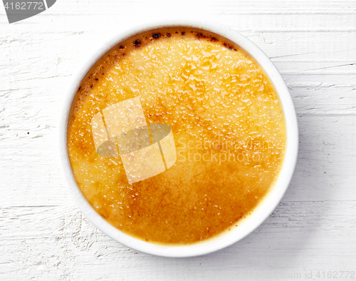 Image of bowl of creme brule on white wooden table