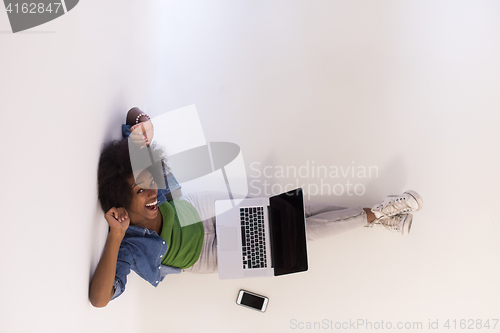 Image of african american woman sitting on floor with laptop top view