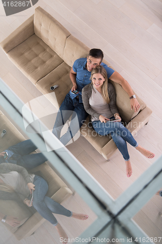 Image of youg couple in living room with tablet top view