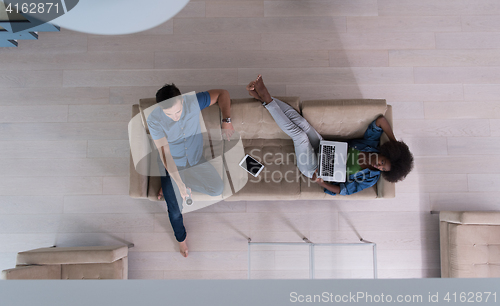 Image of multiethnic couple relaxes in the living room top view