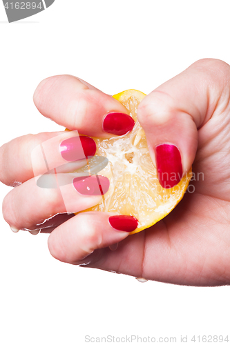 Image of Hand with manicured nails squeeze lemon on white