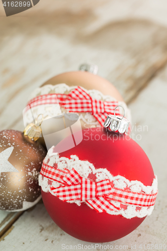 Image of Three Christmas baubles on rustic wood