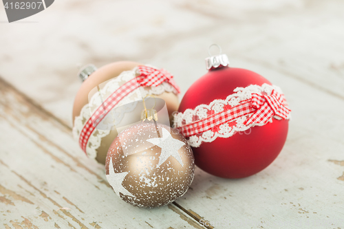 Image of Three Christmas baubles on rustic wood