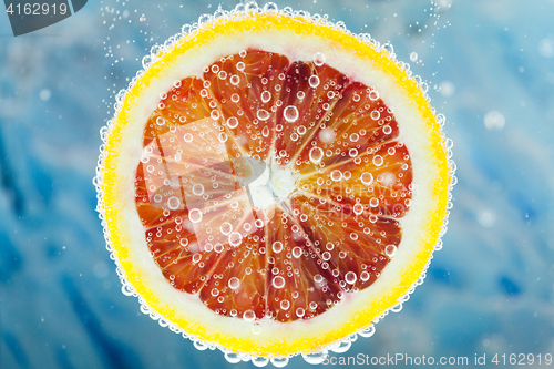 Image of Blood orange slice falling into water