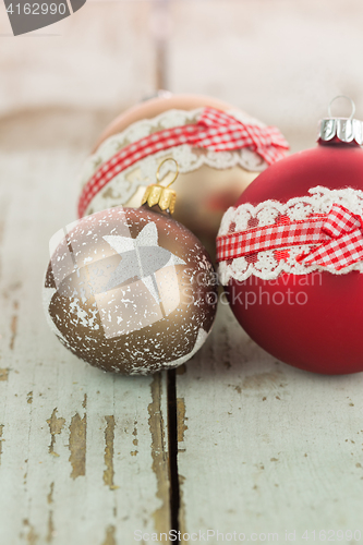 Image of Three Christmas baubles on rustic wood