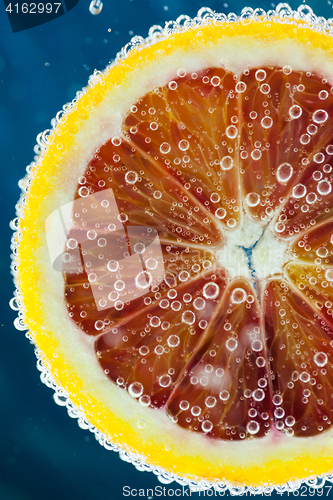 Image of Blood orange slice falling into water