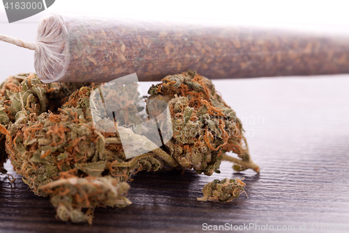 Image of Close up of dried marijuana leaves and joint