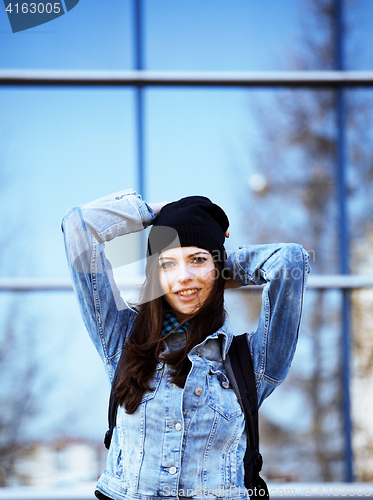 Image of young pretty girl near business building walking