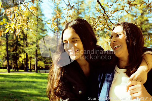 Image of mature real mother with daughter outside autumn fall in park