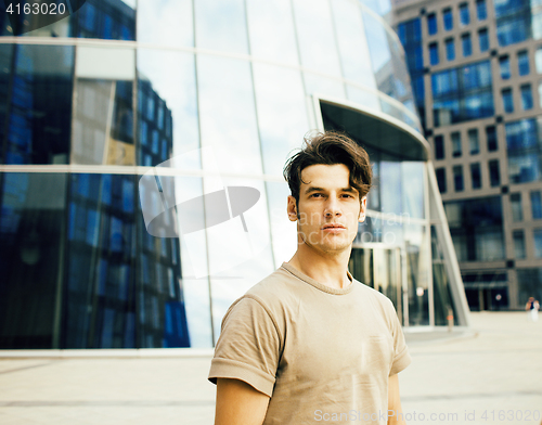 Image of young handsome modern guy posing infront of business building, lifestyle people concept