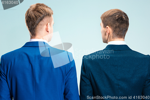 Image of Two young stylish men in a suit. Rear view from the back.