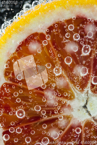 Image of Orange citrus slice falling into water