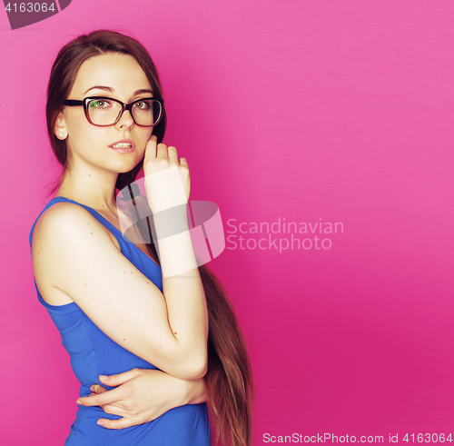 Image of young pretty woman in glasses smiling on pink background