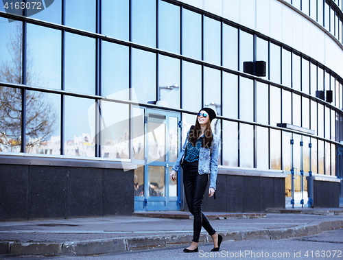 Image of young pretty girl near business building walking
