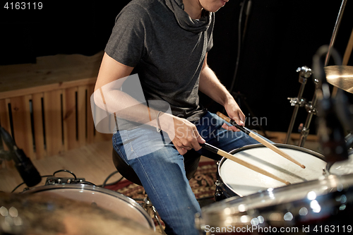 Image of male musician playing drums and cymbals at concert