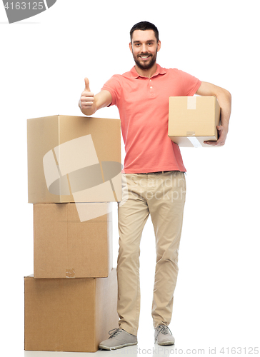 Image of happy man with cardboard boxes showing thumbs up