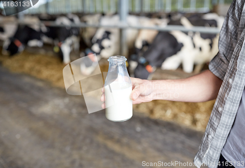 Image of close up of man or farmer with milk on dairy farm