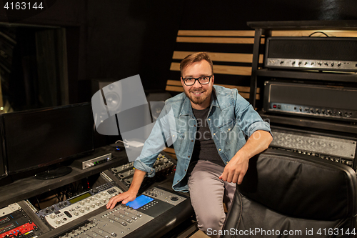 Image of man at mixing console in music recording studio