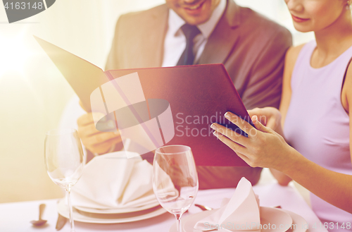 Image of close up of happy couple with menu at restaurant