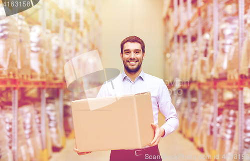 Image of happy man with cardboard parcel box at warehouse