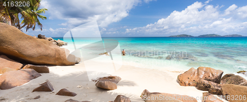 Image of Man enjoying Anse Patates picture perfect beach on La Digue Island, Seychelles.