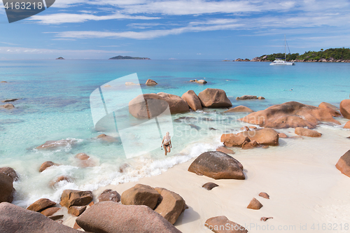 Image of Woman enjoying Anse Lazio picture perfect beach on Praslin Island, Seychelles.