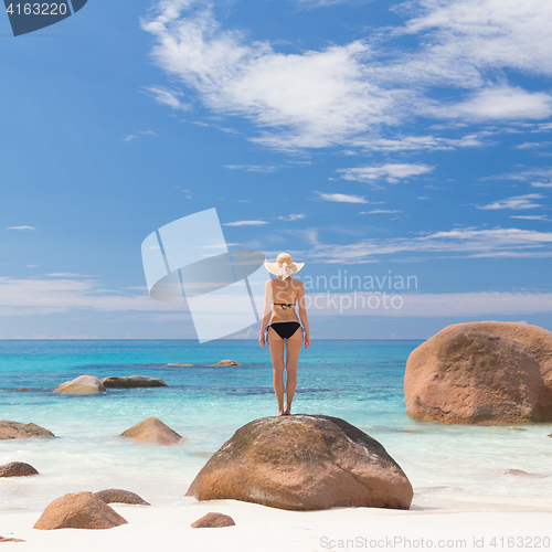 Image of Woman enjoying Anse Lazio picture perfect beach on Praslin Island, Seychelles.