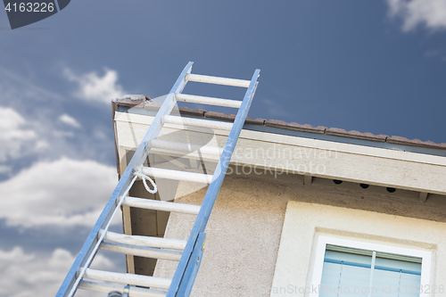 Image of Construction Ladder Leaning Against House