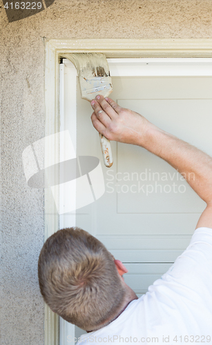 Image of Professional Painter Cutting In With Brush to Paint Garage Door 