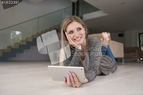 Image of young women used tablet computer on the floor