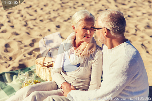 Image of happy senior couple talking on summer beach