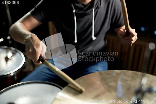 Image of male musician playing drums and cymbals at concert