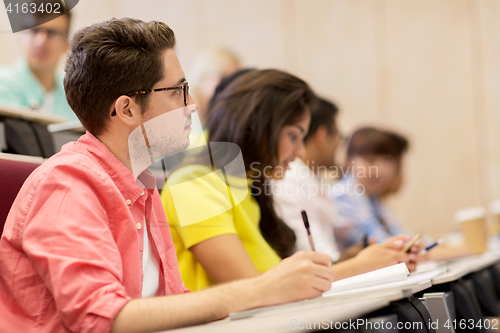 Image of group of students with notebooks in lecture hall