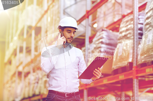 Image of man with clipboard and smartphone at warehouse