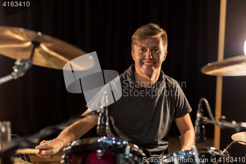 Image of male musician playing drums and cymbals at concert