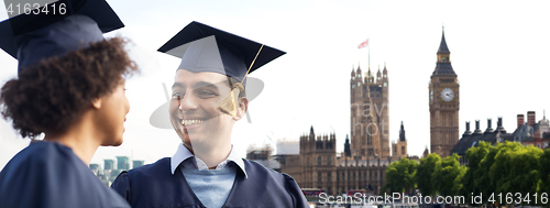 Image of happy students or bachelors over london