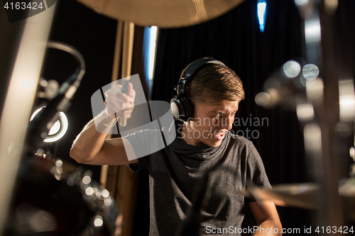 Image of male musician playing drums and cymbals at concert