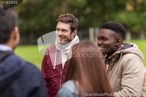 Image of happy friends walking along autumn park