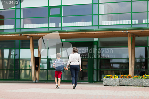 Image of elementary student boy with mother going to school