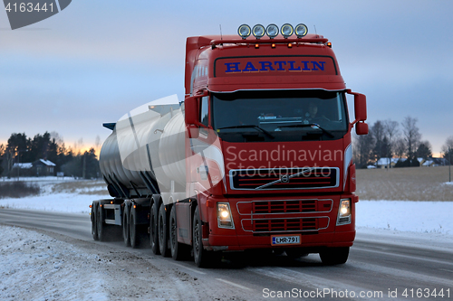 Image of Red Volvo FH Tank Truck Delivers at Dusktime