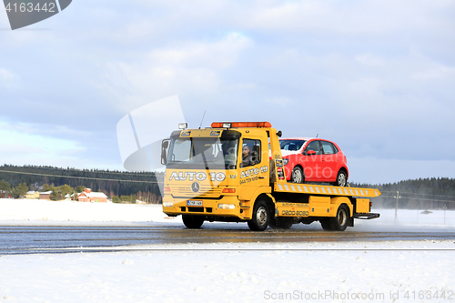 Image of Yellow Tow Truck Carries Breakdown Car